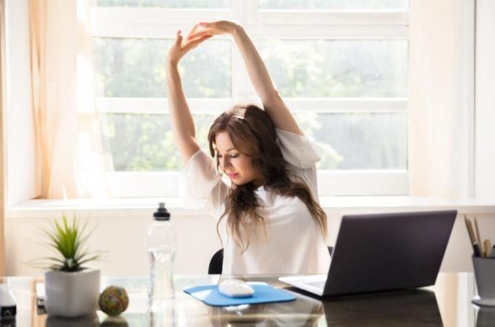 Office worker performing a seated stretch at their desk
